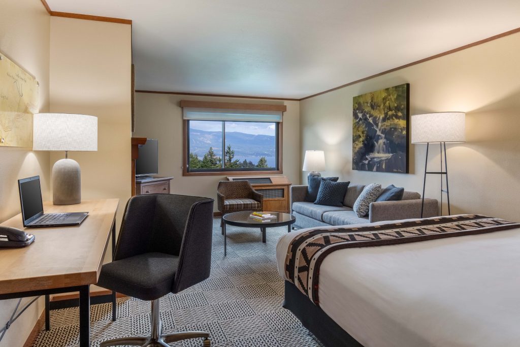 interior hotel guest room with bed, sofa and desk chair